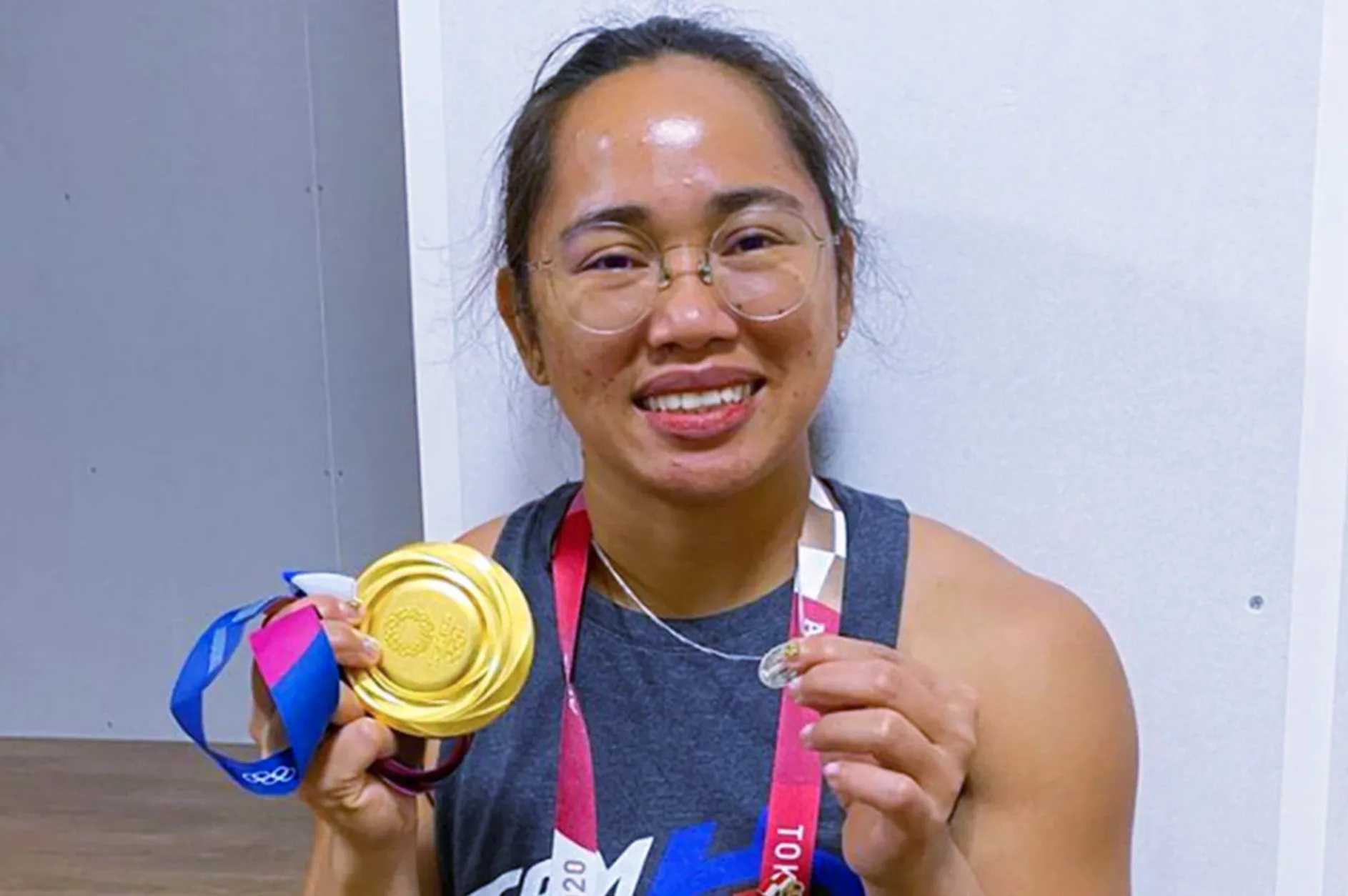 Filipina weightlifter Hidilyn Diaz proudly displays her Olympics gold medal and the Miraculous Medal, a devotional medallion depicting the Virgin Mary.?w=200&h=150